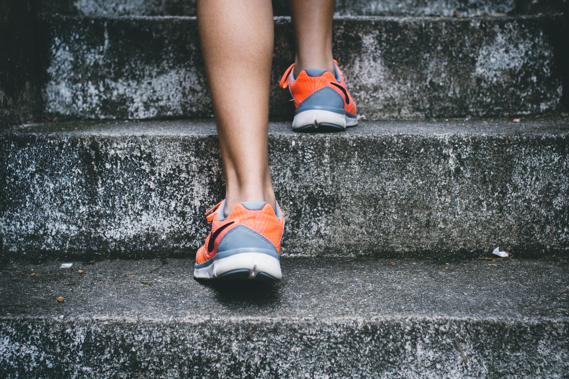 women in sneakers stepping up the stairs