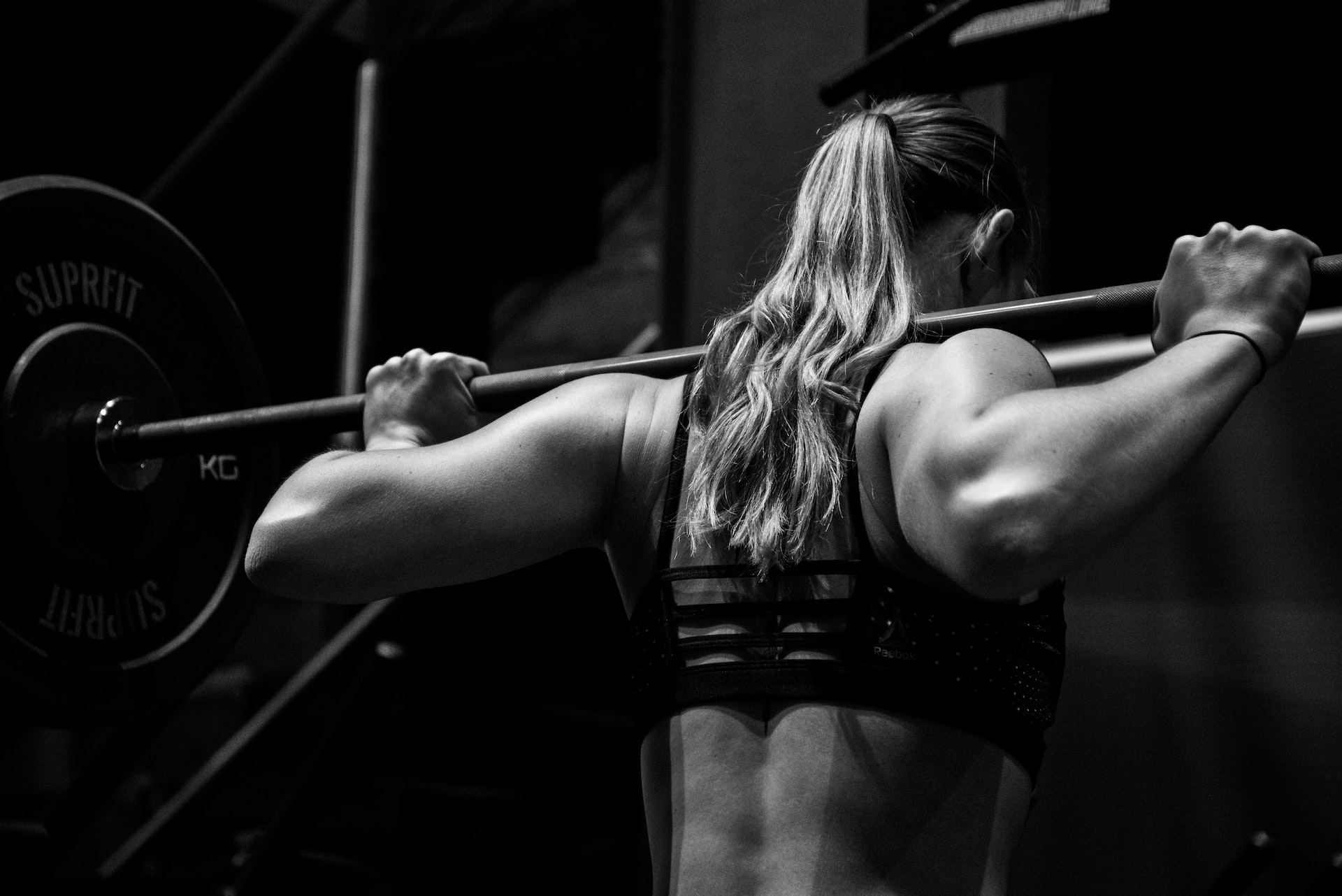 women with barbell on back 