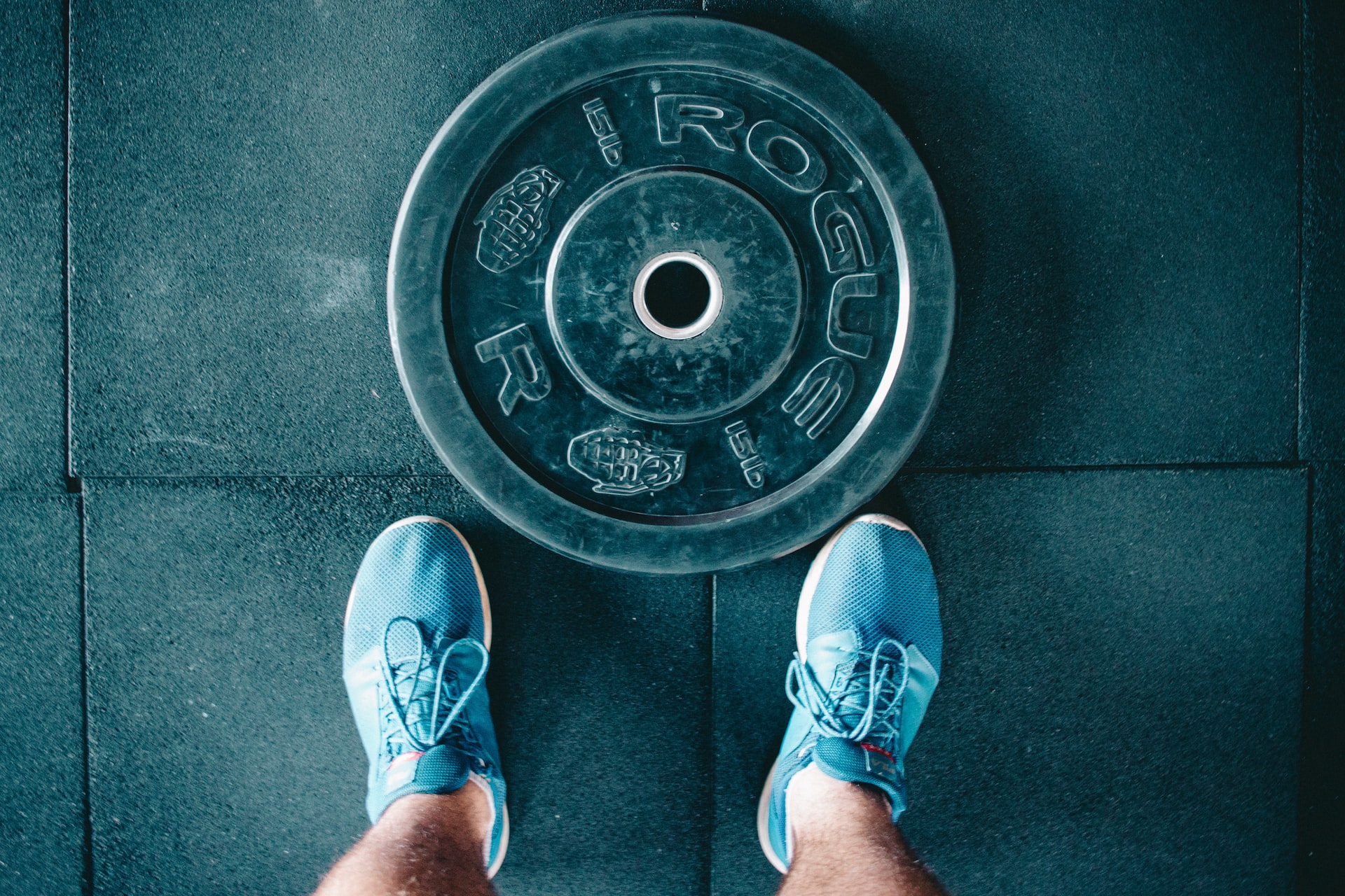 Rogue weight plate and blue sneakers