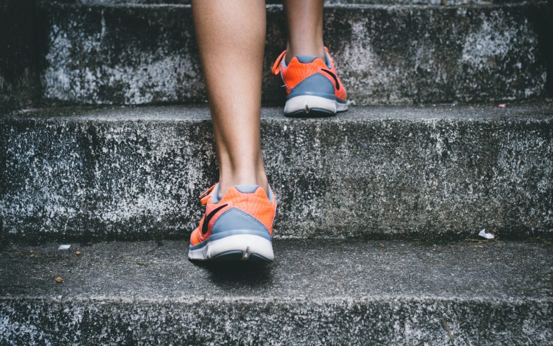 women in sneakers stepping up the stairs